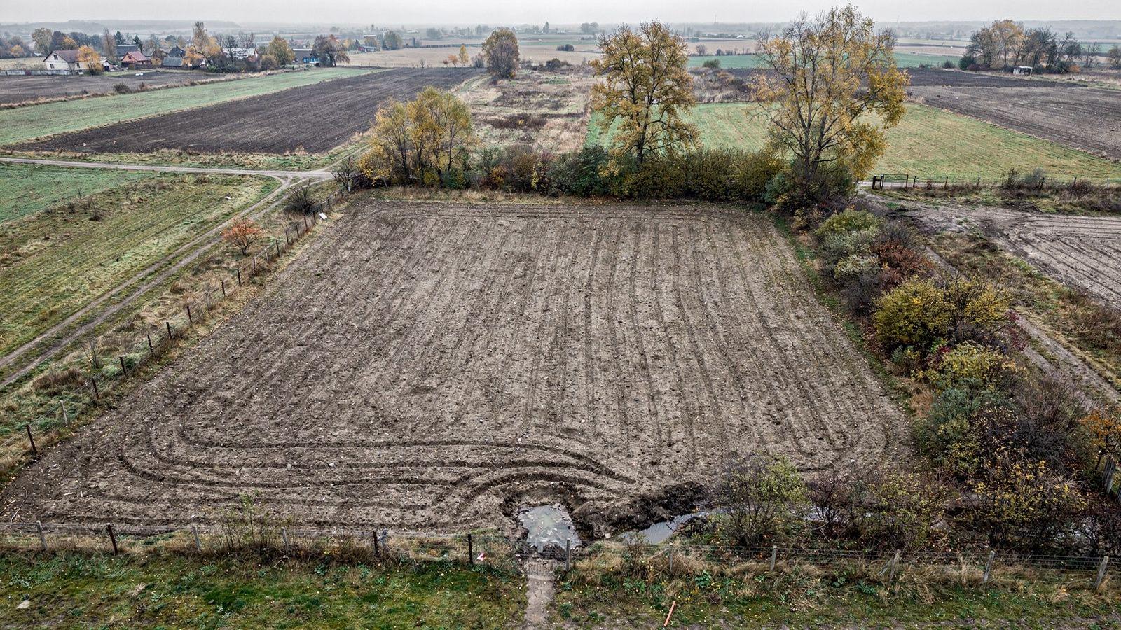 Dated top-down photograph of a 1240 square metre countryside plot in Kyiv Oblast with drainage trench lines cut in October 2024